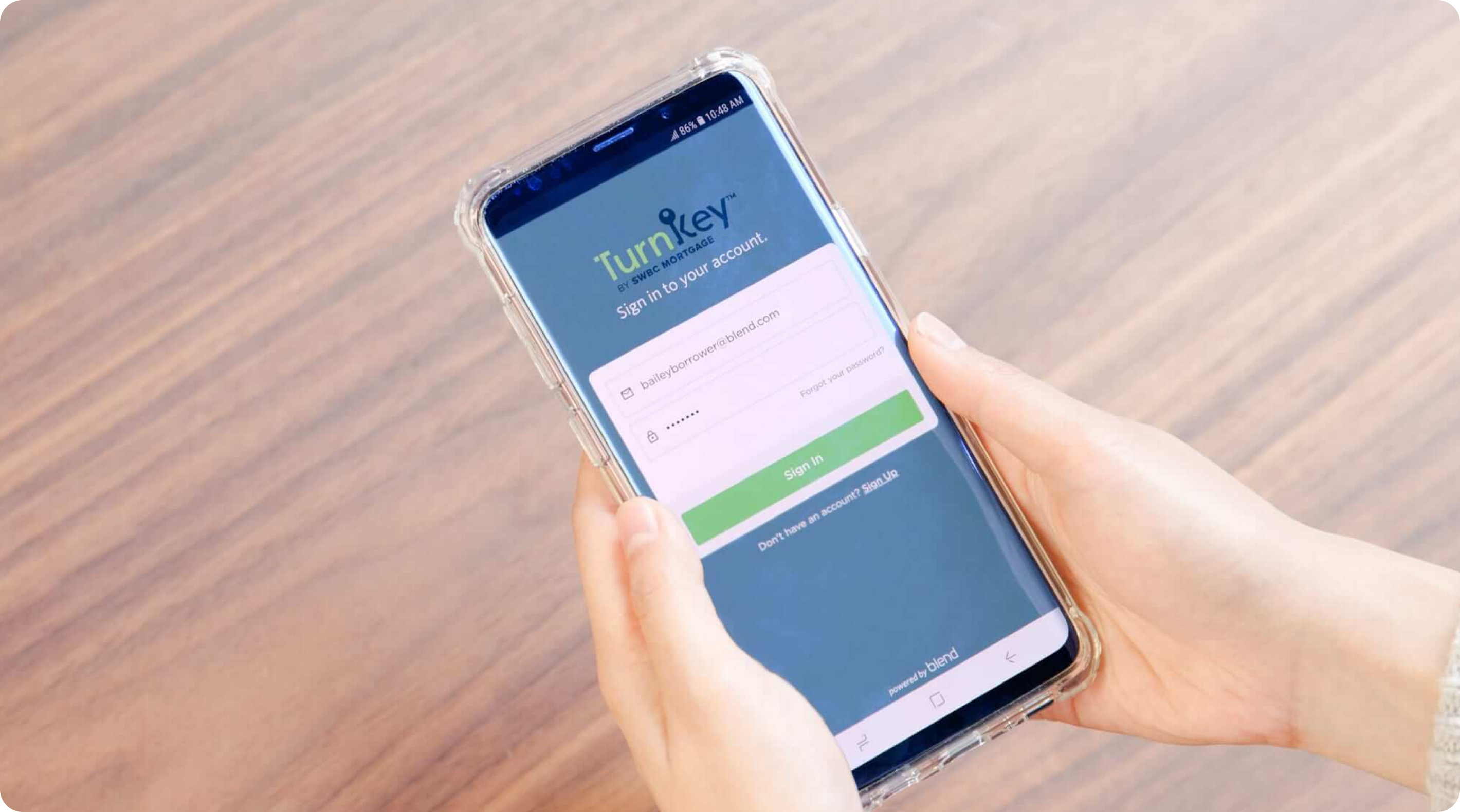 Image of hands holding mobile phone with screen of Turnkey login
