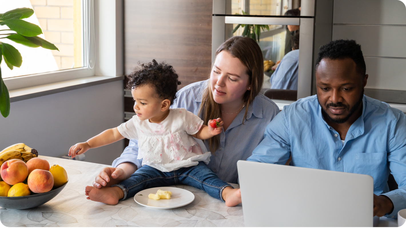 Image of man and woman with laptop and child on table