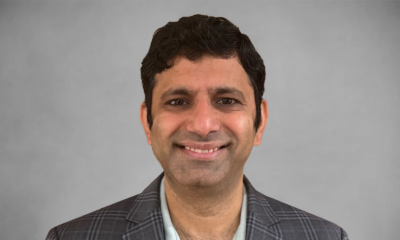 Gray rectangular card with Srini Venkatramani's headshot and white lines behind him