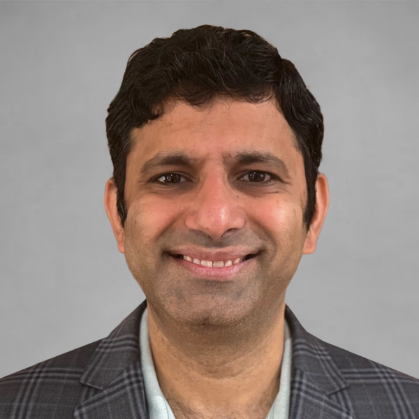 Gray rectangular card with Srini Venkatramani's headshot and white lines behind him