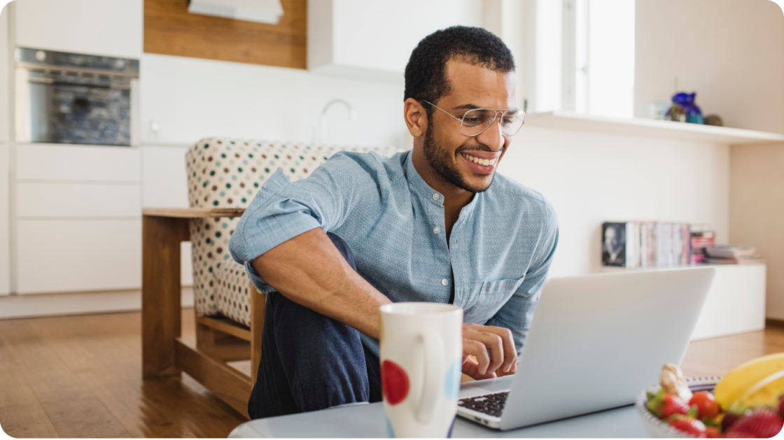 Man in chair with laptop and coffee