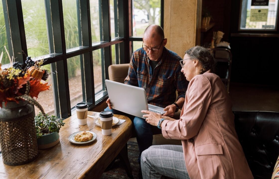 A man and woman banking digitally on a laptop.