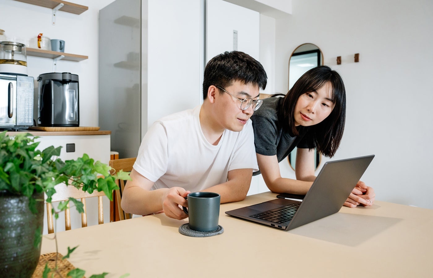 A couple reviews mortgage information together on a laptop at home.